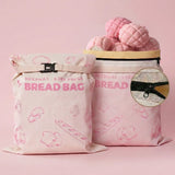 Pink reusable beeswax bread bags with bread pattern for fresh bread and baked goods storage