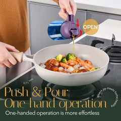 Blue glass cooking oil dispenser bottle with purple pouring olive oil into a wok with seafood and vegetables
