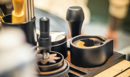 Barista tools and coffee grinder equipment on a wooden coffee counter