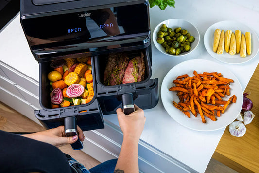 Healthy air fryer meal preparation showing low-oil cooking with vegetables and sweet potato fries in a modern kitchen