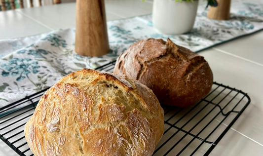 Two freshly baked artisan loaves cooling on a rack before storage