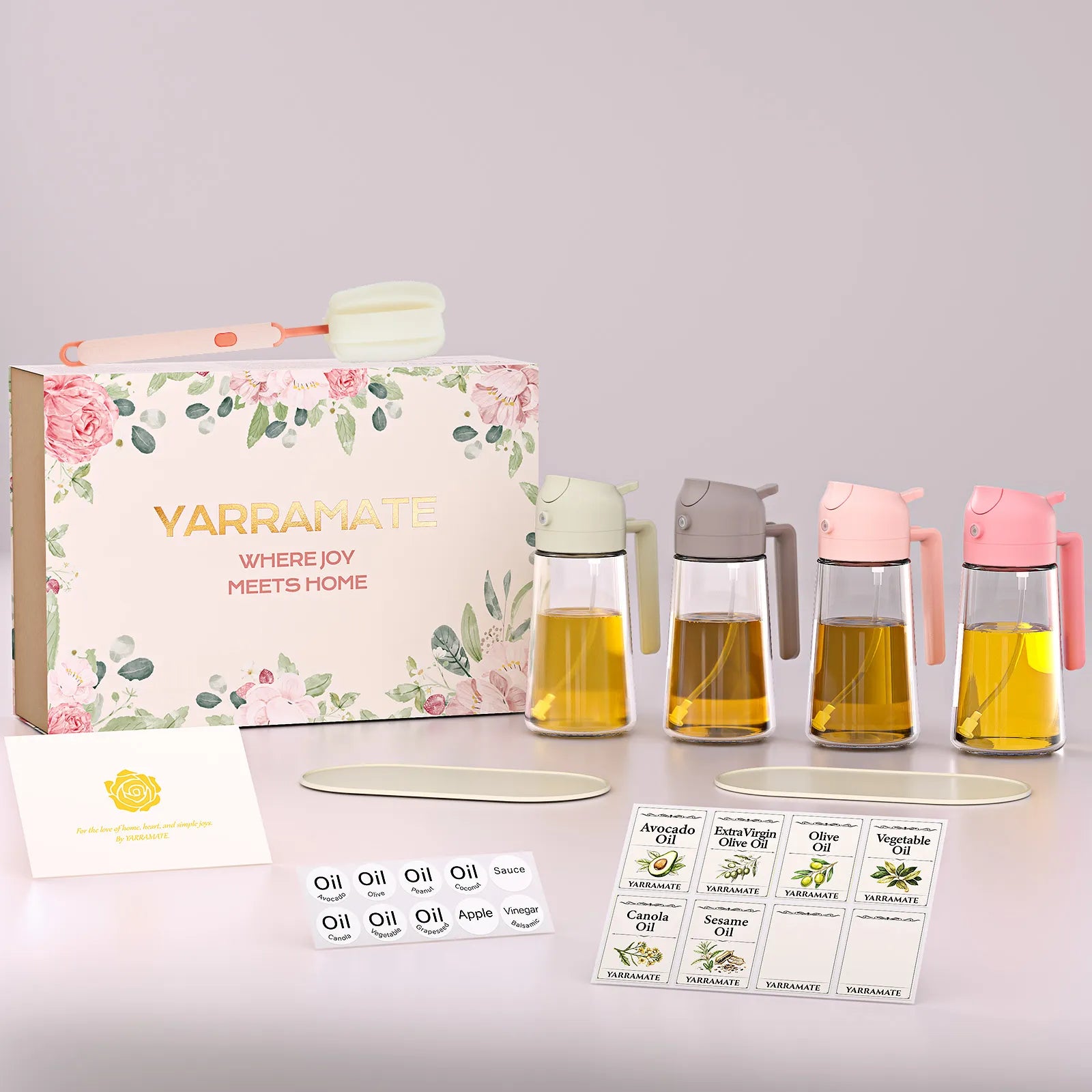 A complete Yarramate glass oil dispenser set layout, featuring two 16oz clear glass bottles, two UV-protective dark glass sprayers, dual non-slip silicone mats, a custom cleaning brush, and aesthetic pantry organization labels.