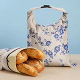 Blue floral beeswax bread bag with fresh baguettes for reusable bread storage