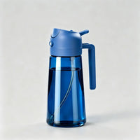 Blue glass oil dispenser bottle with Blue lid and handle for kitchen cooking on light grey background