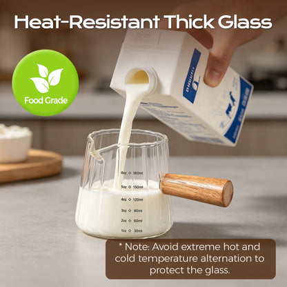 Milk poured from a carton into a fluted glass measuring pitcher with a wooden handle.