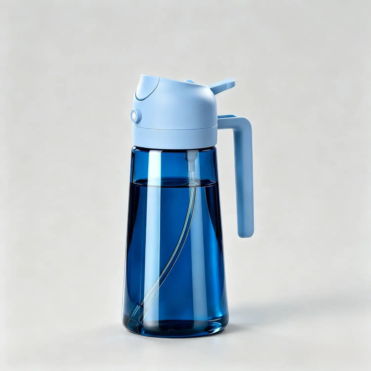 Blue glass oil dispenser bottle with sky blue lid and handle for kitchen cooking on light grey background