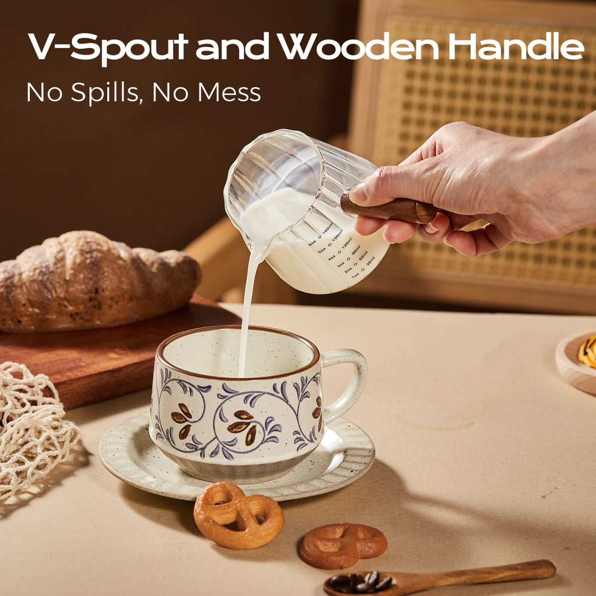 Milk poured from a fluted glass pitcher with a wooden handle into a patterned cup.