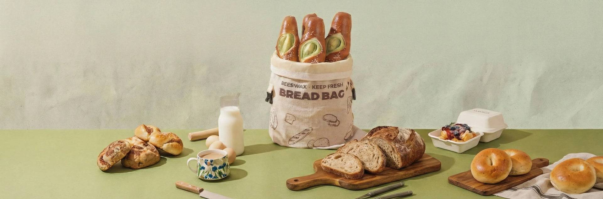 Beeswax keep fresh bread bag centerpiece on a breakfast table with milk, eggs, and various fresh breads.