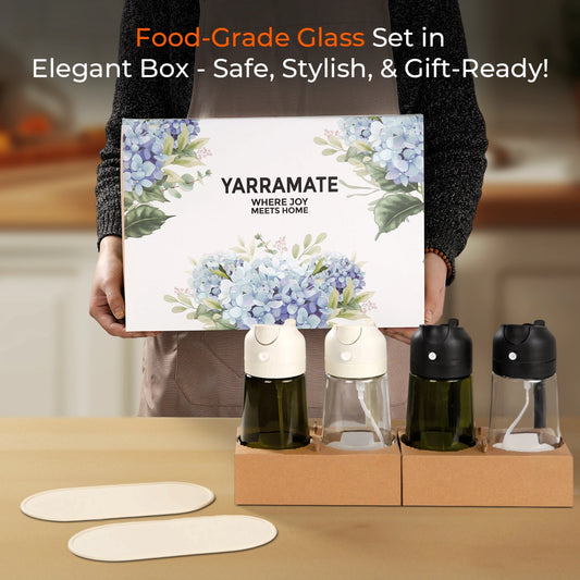 Person holding a floral YARRAMATE gift box behind four glass oil sprayers with white and black lids.