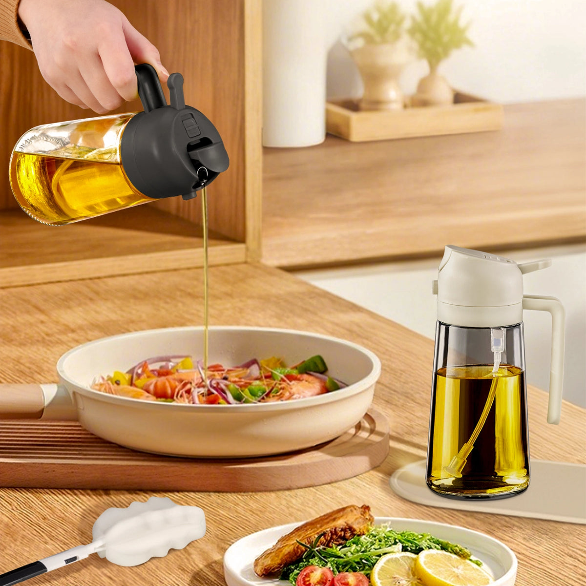 Black-lid oil dispenser pouring oil over pasta beside a white-lid glass oil sprayer.