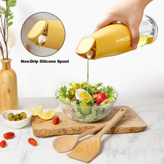 Hand pouring oil over a fresh salad using a yellow oil dispenser pourer