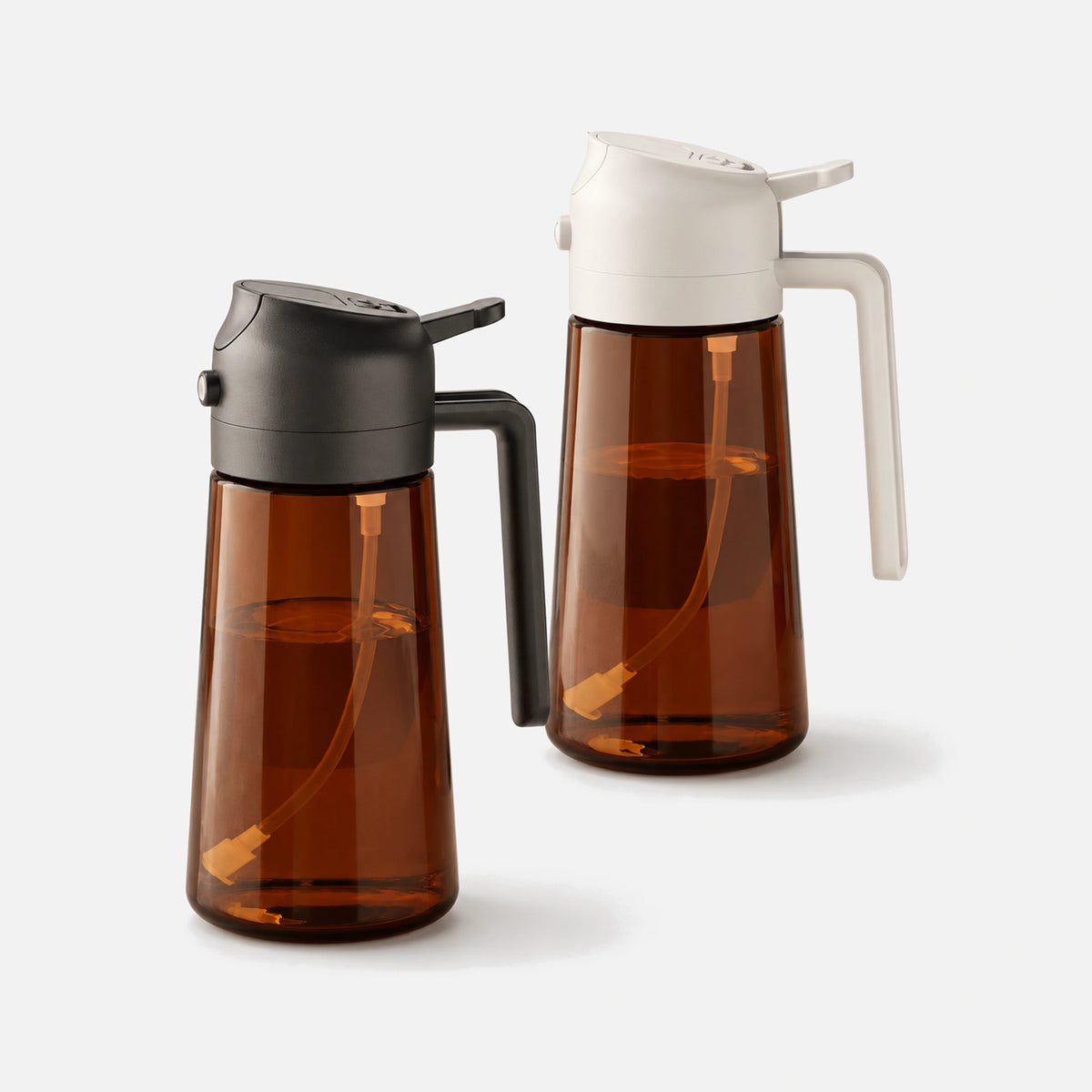Two dark brown glass oil sprayers with black and white spray heads.