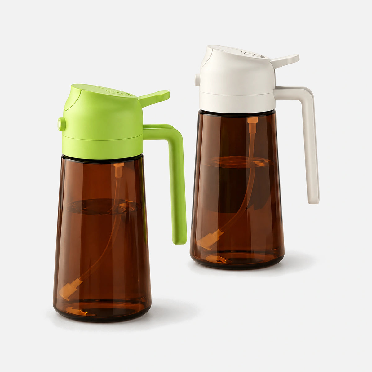 Two dark brown glass oil sprayers with white and green spray heads.