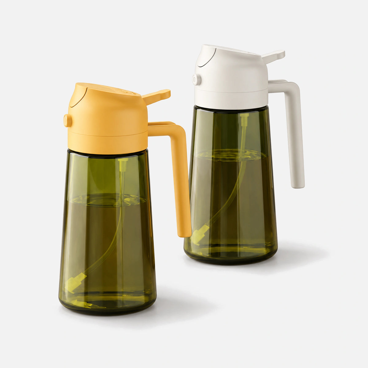 Two dark green glass oil sprayers with white and orange spray heads.
