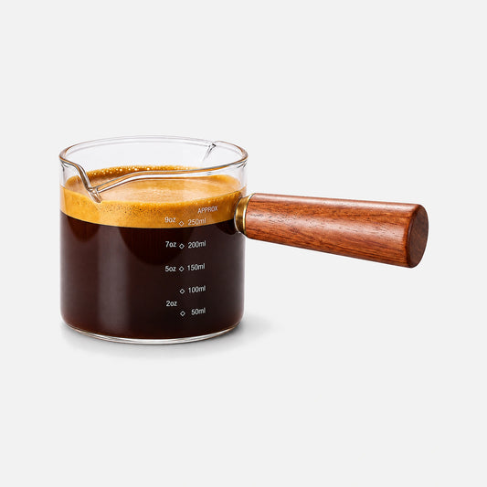Glass measuring cup with dual spout and wooden handle.