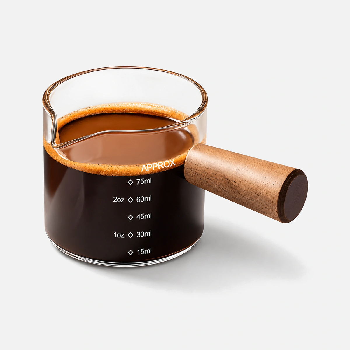 Glass espresso measuring cup with a wooden handle and single pouring spout.