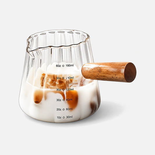 Ribbed glass measuring cup with a wooden handle.