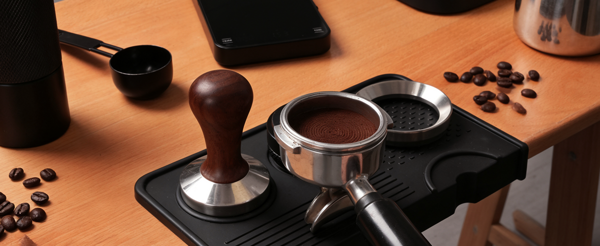 Portafilter resting on the black silicone espresso mat.