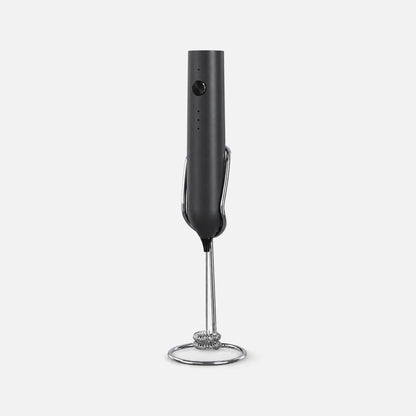 Black rechargeable milk frother with a stand.